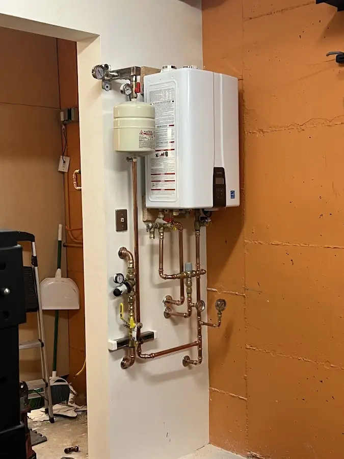 Plumbing technician inspecting water heater connections in Dickinson